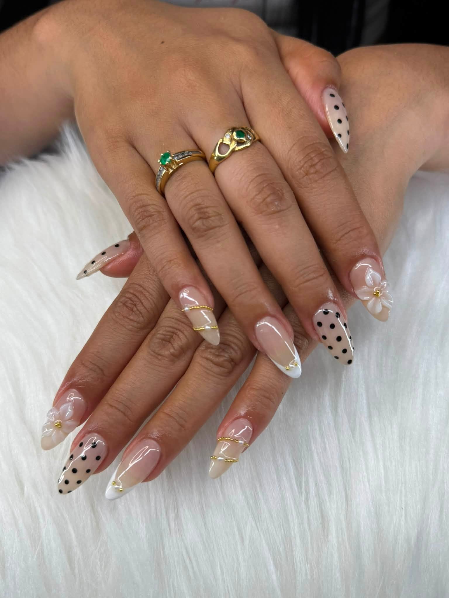 Uñas almendra con puntitos negros y flores blancas 3D